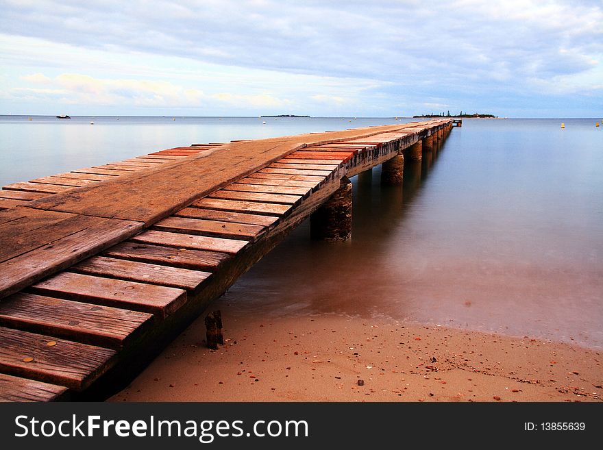 Beautiful view of New Caledonia. Wooden dock at Anse Vata beach Noumea, New Caledonia. Beautiful view of New Caledonia. Wooden dock at Anse Vata beach Noumea, New Caledonia
