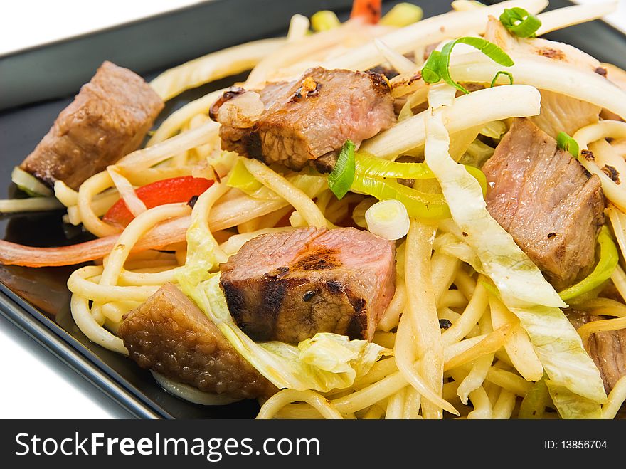 Noodles and three kinds of meat on black plate