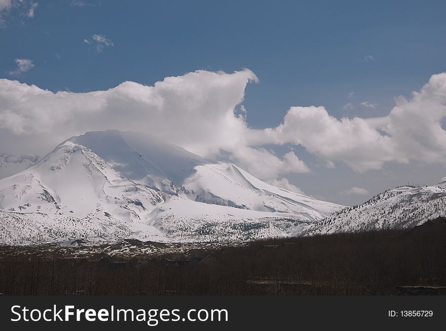 Springtime view of Mount Saint Helens with heavy snow pack and clouds