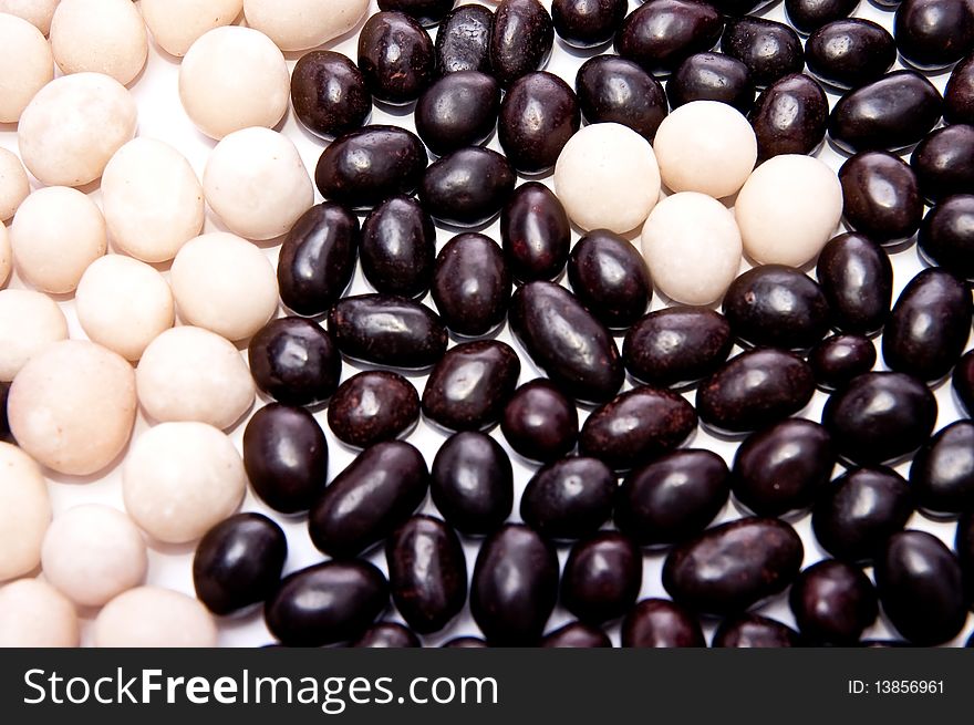 Nuts in black and white chocolate on white background. Nuts in black and white chocolate on white background