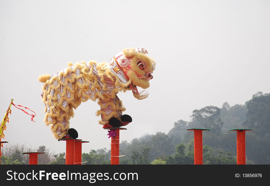 A chinese lion dance on high iron pole.