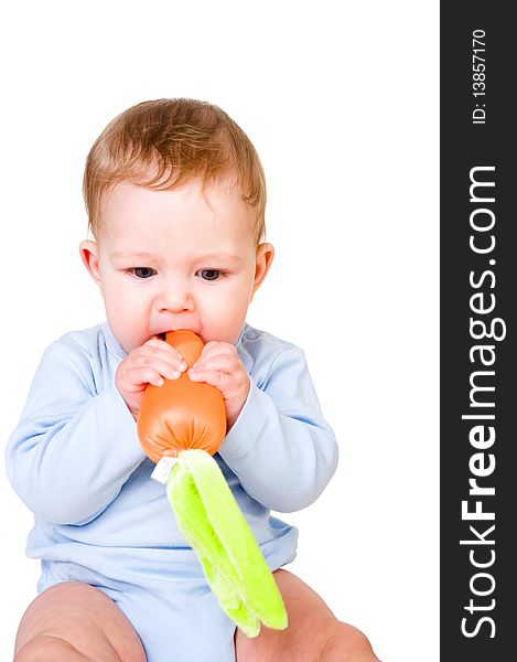 Baby boy eating toy carrot. Baby boy eating toy carrot