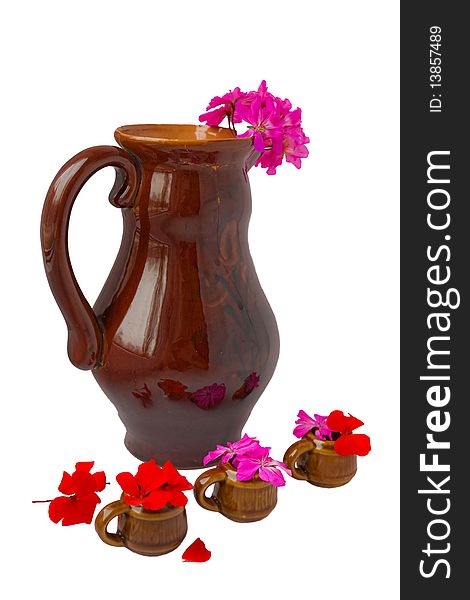 The big ceramic jug with a pink geranium also three small mugs with a red and pink geranium. The big ceramic jug with a pink geranium also three small mugs with a red and pink geranium