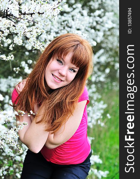 Redheaded girl in blossom garden