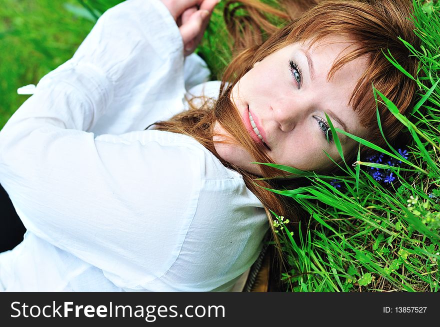 Redheaded girl laying on the spring meadow. Redheaded girl laying on the spring meadow