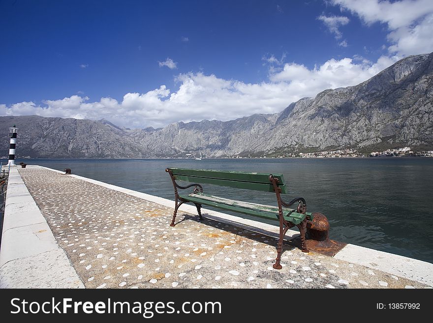 A green public bench facing out over Kotor Bay, Montenegro. A green public bench facing out over Kotor Bay, Montenegro