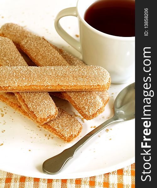 Cookies strewed by sugar and cup of tea