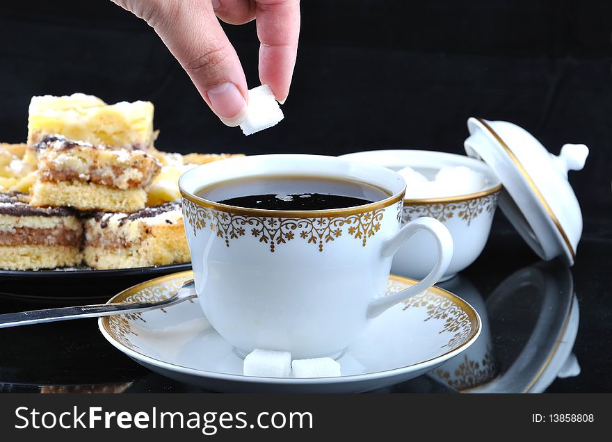 Hand, wich gives sugar lump to cup of coffee. Hand, wich gives sugar lump to cup of coffee