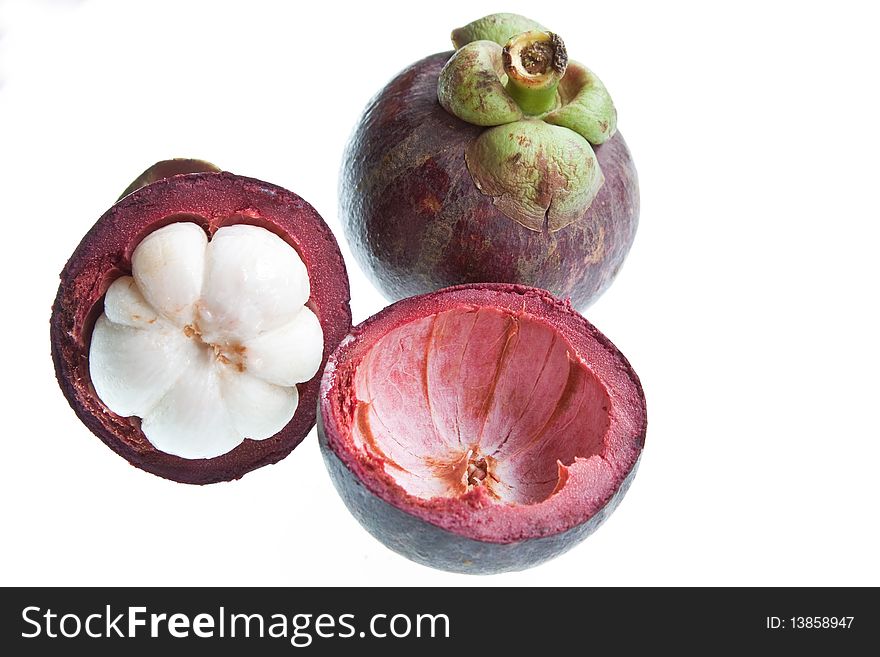 Mangosteens, one halved, isolated agaionst a white background. Mangosteens, one halved, isolated agaionst a white background