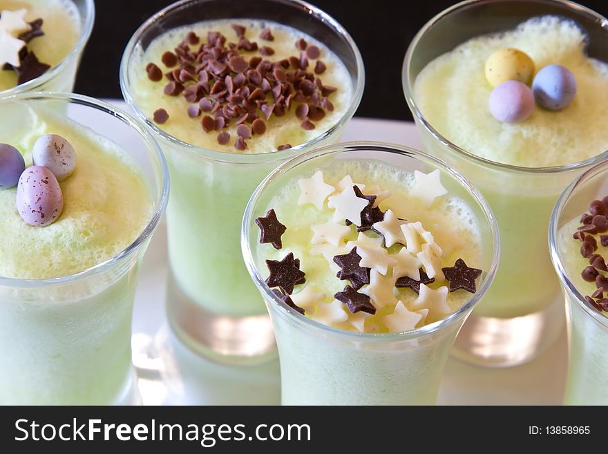 Glasses of lime mousse decorated with Easter eggs, chocolate stars & sprinkles. Glasses of lime mousse decorated with Easter eggs, chocolate stars & sprinkles