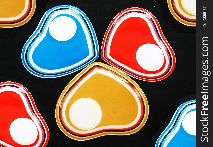 A background of colored heart shaped designer saucers. A background of colored heart shaped designer saucers