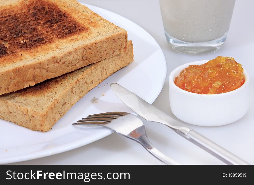 Studio shot of toasted wholewheat bread and sweet orange jam