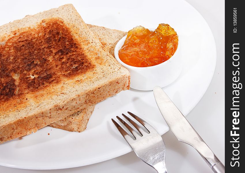 Studio shot of toasted wholewheat bread and sweet orange jam