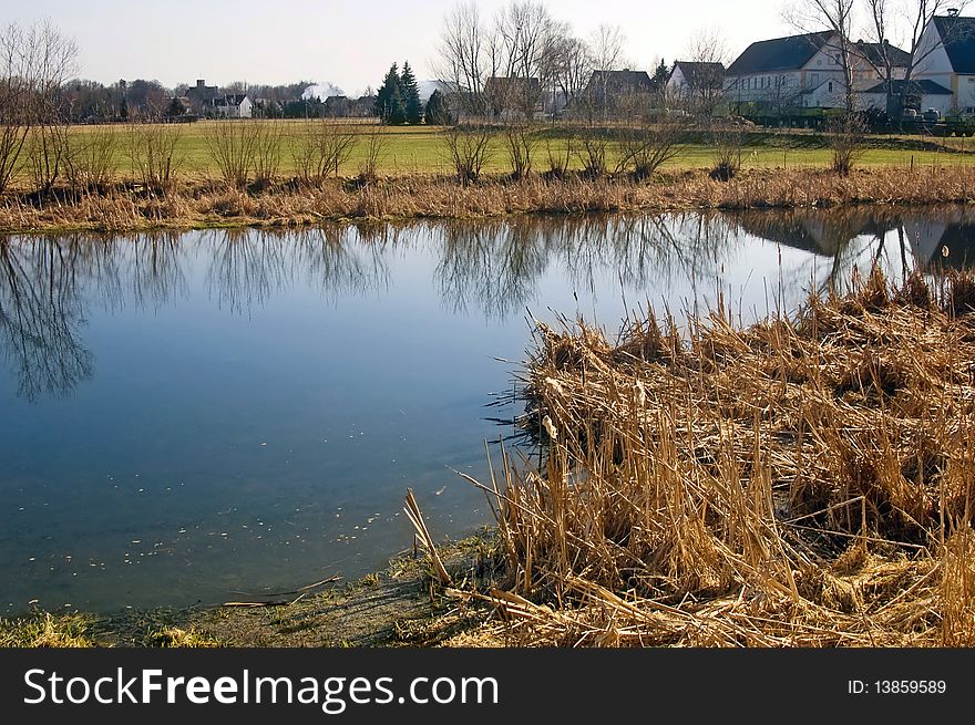 Quiet pond in the spring in a village