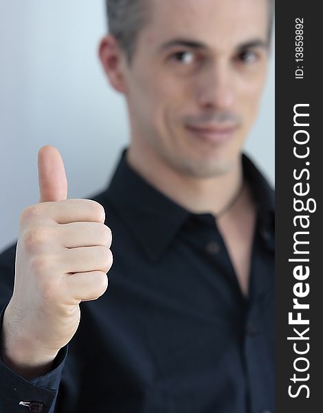 Man with the thumb pointing upwards as a sign of success