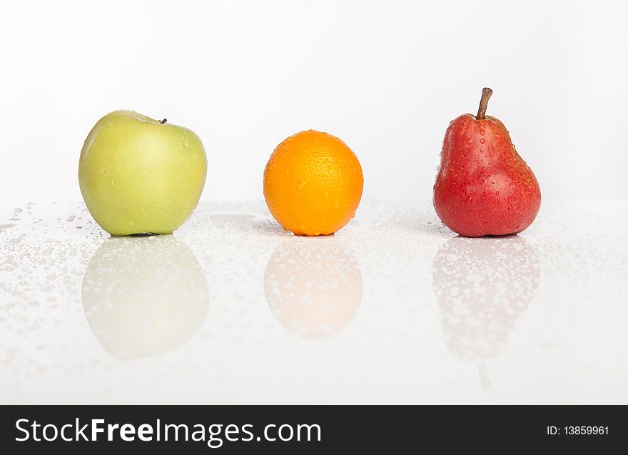 Apple orange pear row with water drops