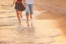 Couple In Love Runs Barefoot On The Sea Along The Surf At Sunset. Honeymoon, Valentine, Happiness And Love Royalty Free Stock Images