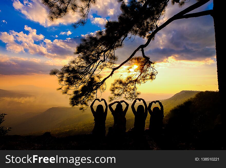 Silhouette of happy young couple in love looking view sunset on the mountain. Romantic couple in love