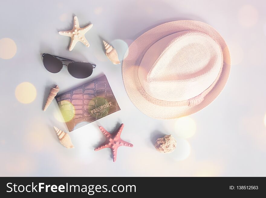 Summer vacation concept. Hat, sunglasses, passport, starfishes and seashells on blue background.