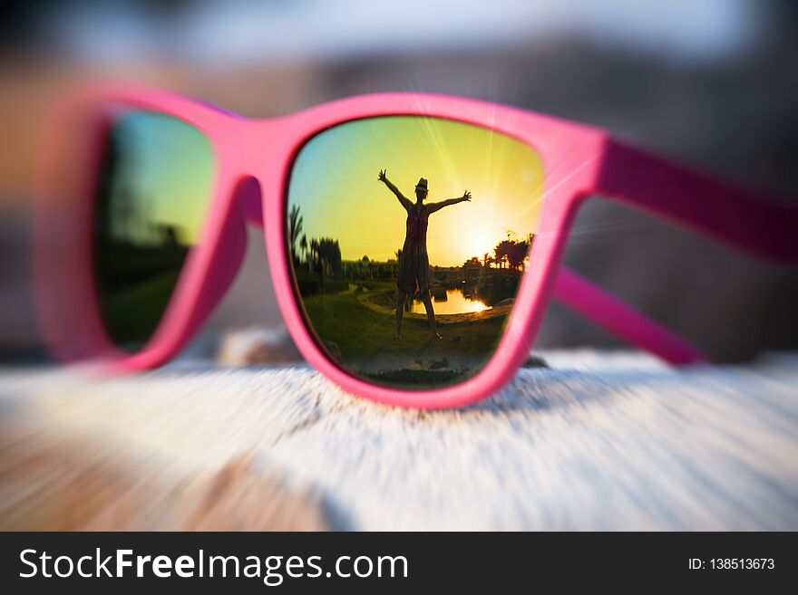 Excited girl silhouette in the pink sunglasses