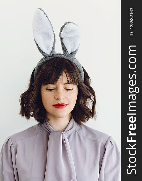 Beautiful young woman in bunny ears calm portrait on white background indoors, space for text. Easter hunt concept. Happy Easter