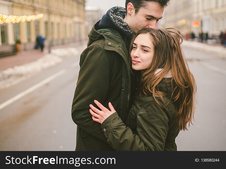 Theme love and romance. Caucasian young people heterosexual couple in love students boyfriend girl hugging and kissing on center