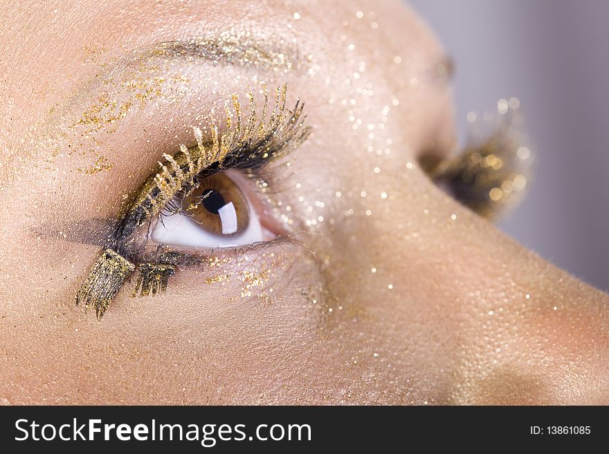 Fashion gold make-up, women eye close-up. Fashion gold make-up, women eye close-up