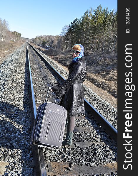 Woman in a scarf and sunglasses on the railroad. Woman in a scarf and sunglasses on the railroad