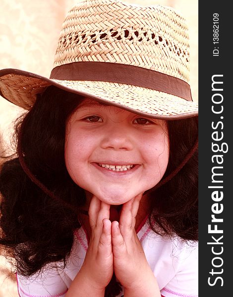 Cute little girl wearing a cowboy hat with hands on chin. Cute little girl wearing a cowboy hat with hands on chin