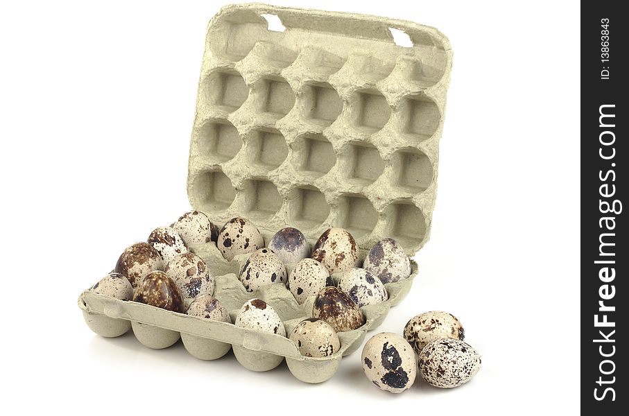 Quail eggs in a box on a white background