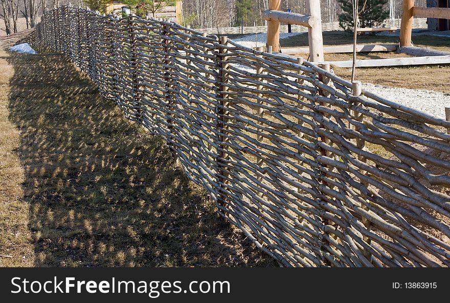 A fence of tree branches.Shadow.