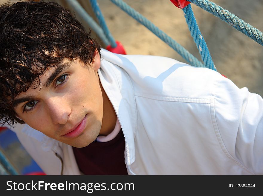 Young adult man in white, on a playground