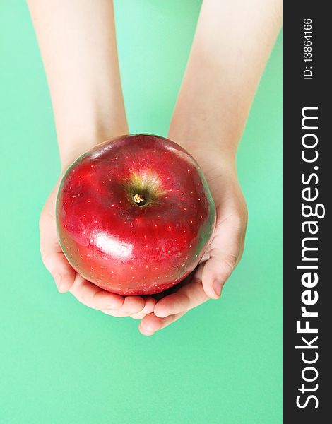 Child Holding A Red Apple On Green Background Vert
