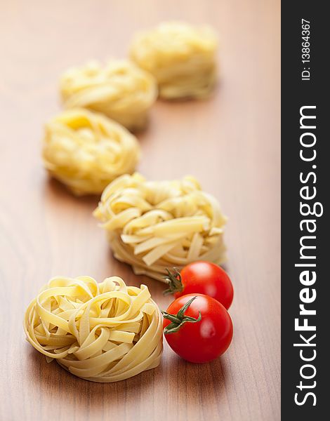 Raw pasta tagliatelle and tomatoes