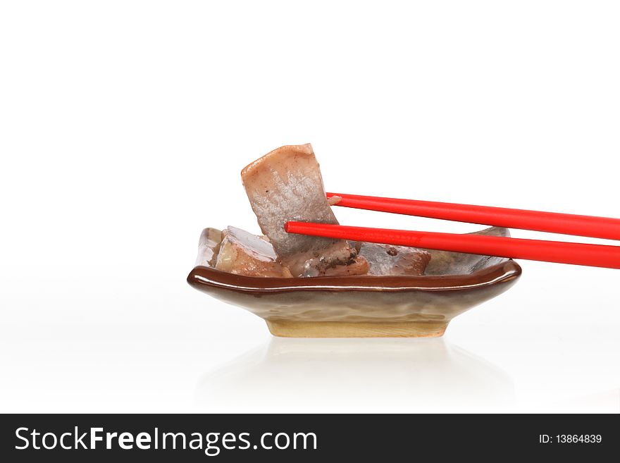 Pair of red chopsticks lying on plate with fish. Isolated on white with clipping path. Pair of red chopsticks lying on plate with fish. Isolated on white with clipping path