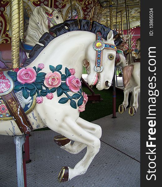 Ao old carousel horse is adorned with beautiful roses. Ao old carousel horse is adorned with beautiful roses