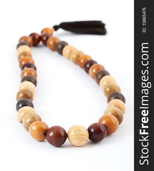 Wooden beads from various breeds of a tree on a white background. Wooden beads from various breeds of a tree on a white background.