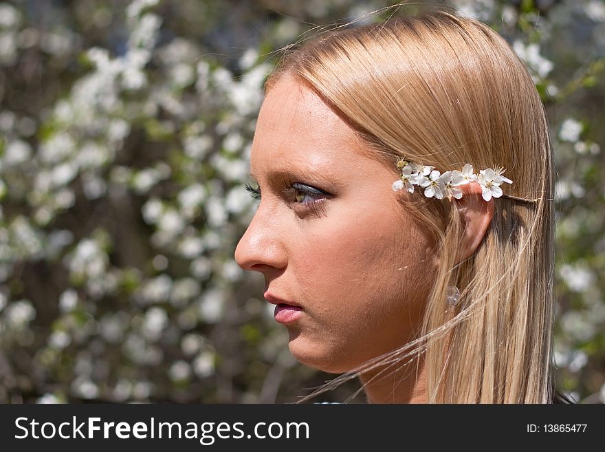 Blond girl in front of blossomed tree on early spring