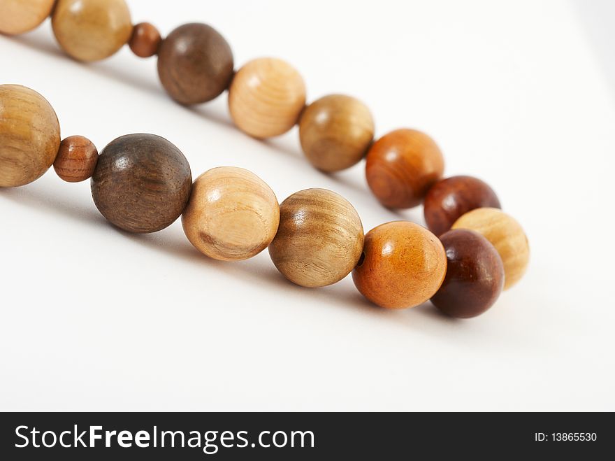Wooden beads from various breeds of a tree on a white background. Wooden beads from various breeds of a tree on a white background.