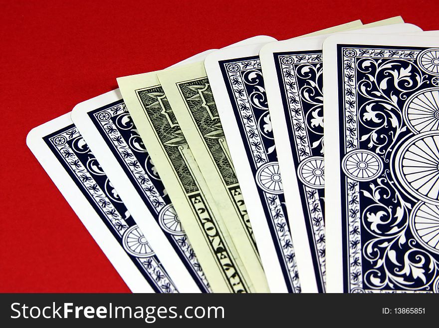 Fan from playing cards and dollars on a red background. Fan from playing cards and dollars on a red background