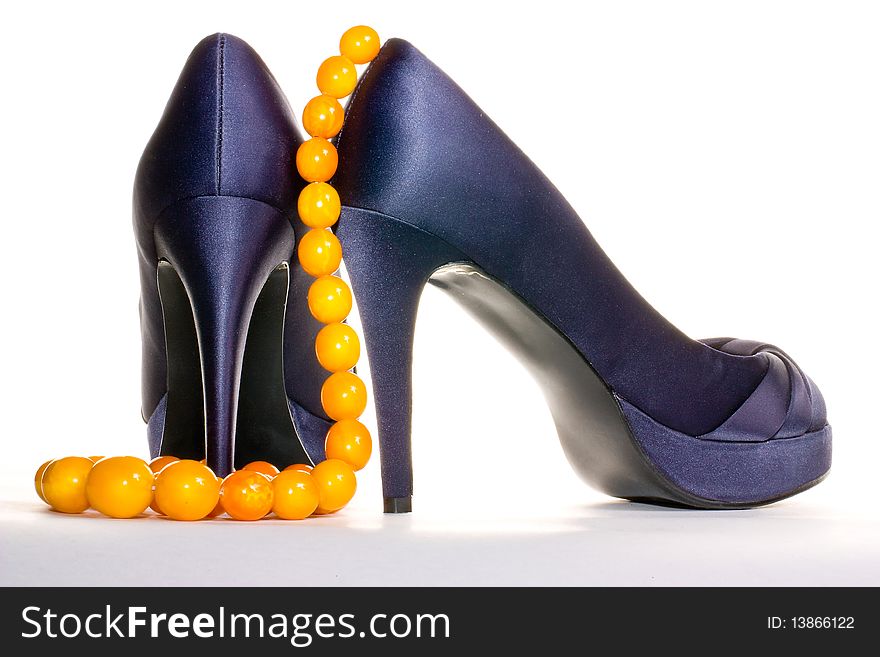 Purple shoes and amber necklace isolated on the white background