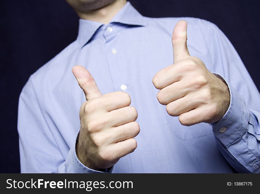 Happy young businessman in a blue shirt with a finger gesture OK. Happy young businessman in a blue shirt with a finger gesture OK