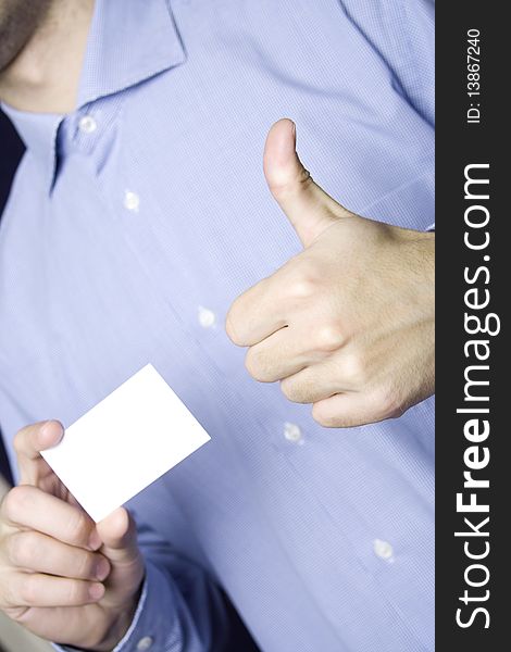 Business young man in a blue shirt holding a blank business card. Another hand the excitement thumb up. Business young man in a blue shirt holding a blank business card. Another hand the excitement thumb up