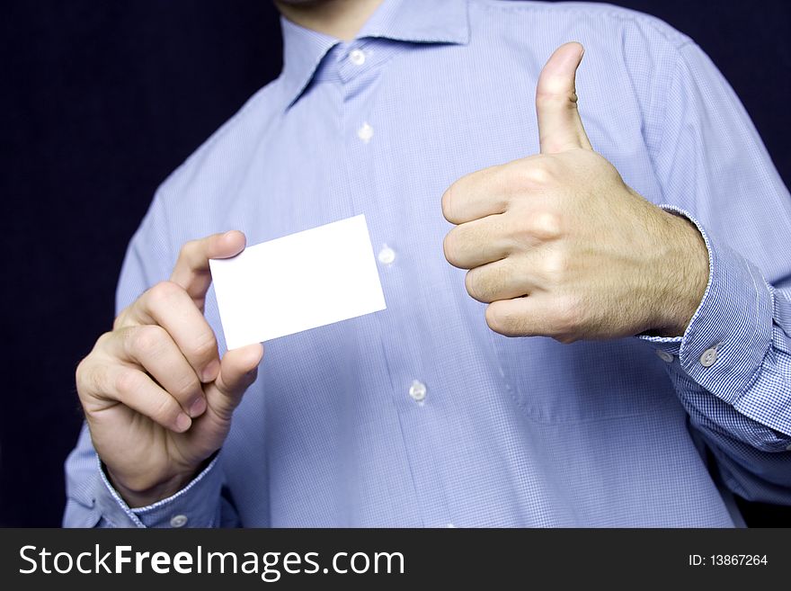 Business young man in a blue shirt holding a blank business card. Another hand the excitement thumb up. Business young man in a blue shirt holding a blank business card. Another hand the excitement thumb up