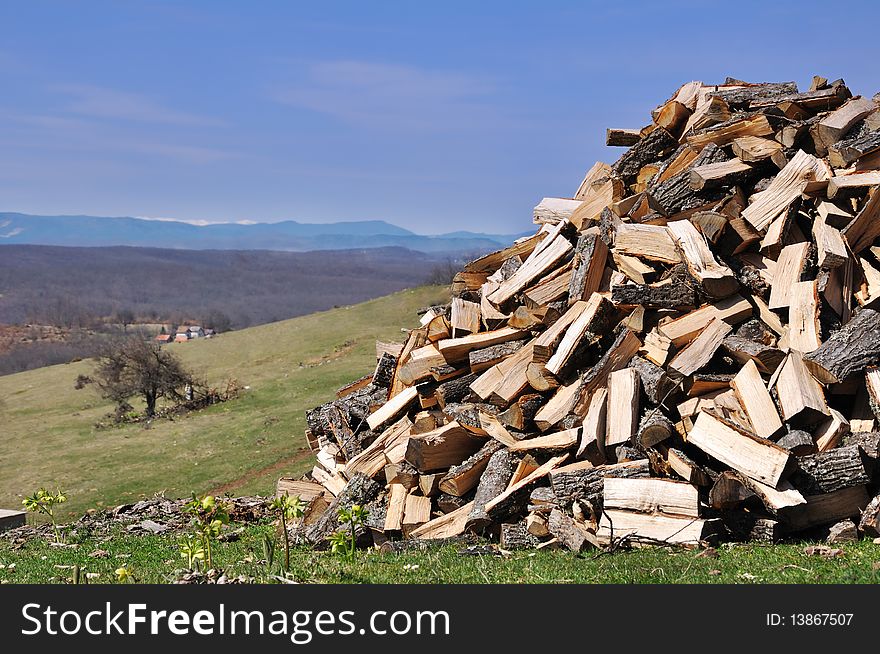 Woodpile on village panorama with blue sky