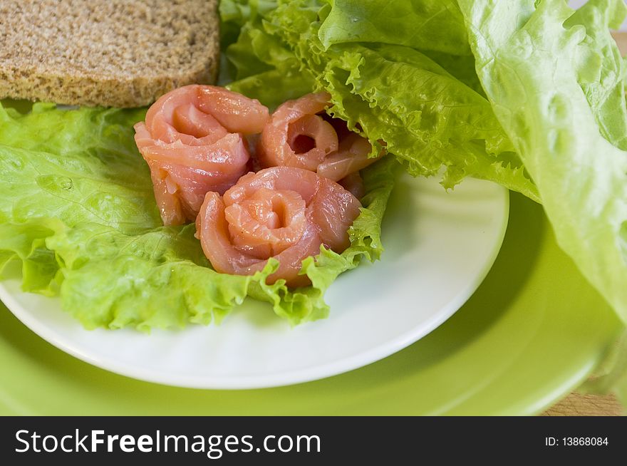 Three slices of a salmon on salad sheet. Three slices of a salmon on salad sheet