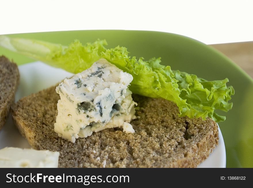 Slice of bread with blue cheese on a white plate