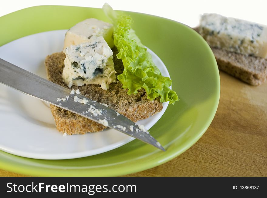 Slice of bread with blue cheese on a white plate. Slice of bread with blue cheese on a white plate