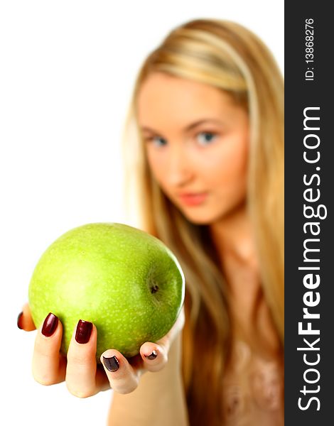 Young woman holding an apple into the camera - focus on apple. Young woman holding an apple into the camera - focus on apple