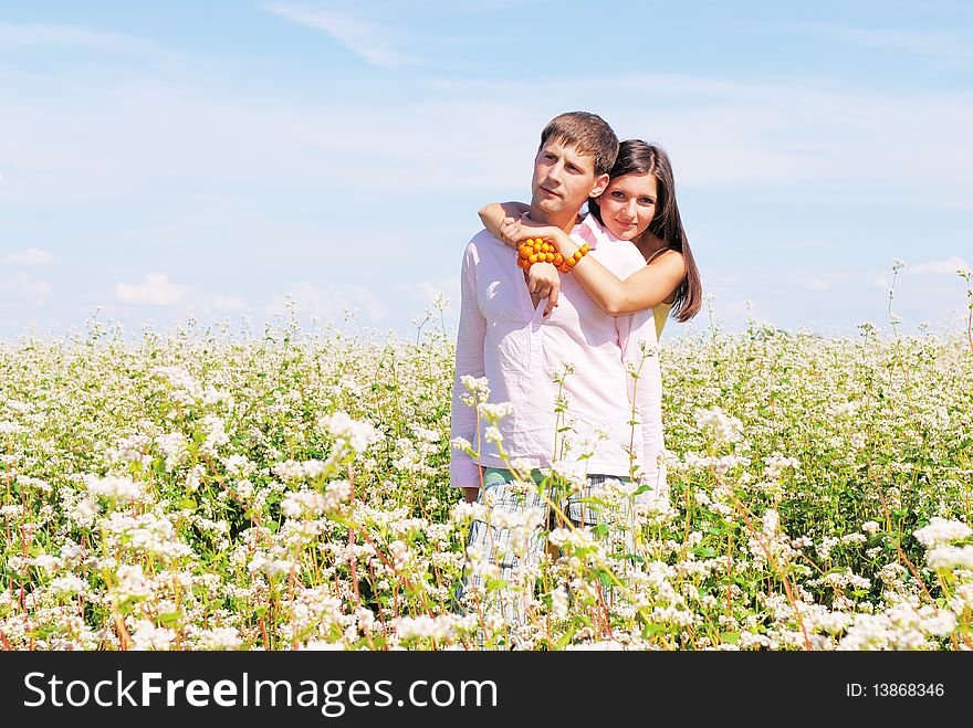 Young lovely couple in a spring field of flowers